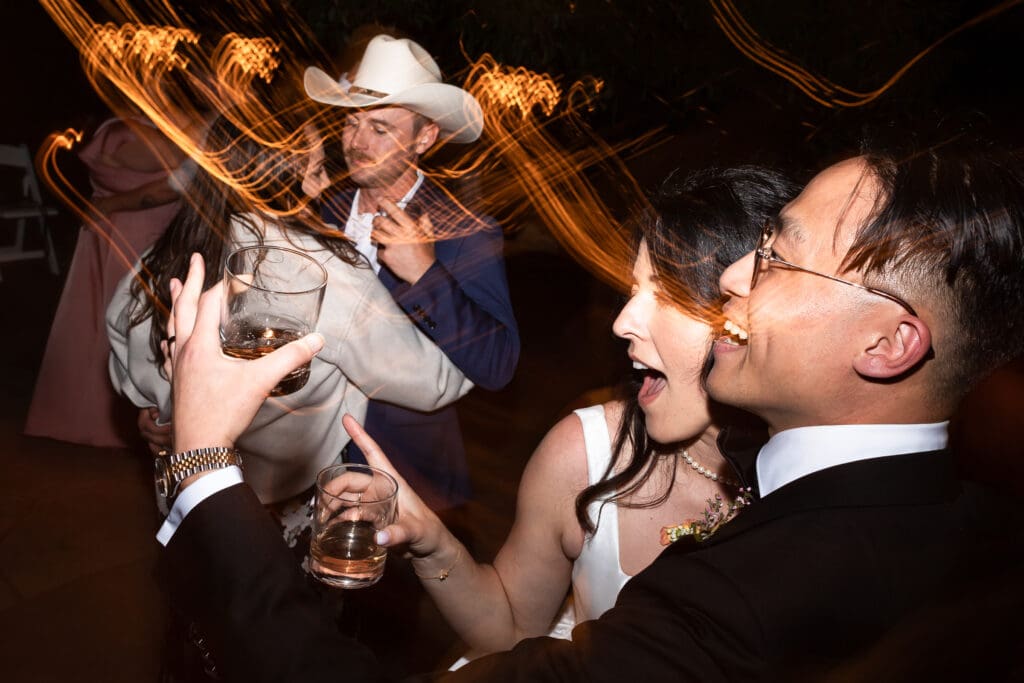 Bride and groom singing, drinking and dancing while at wedding reception