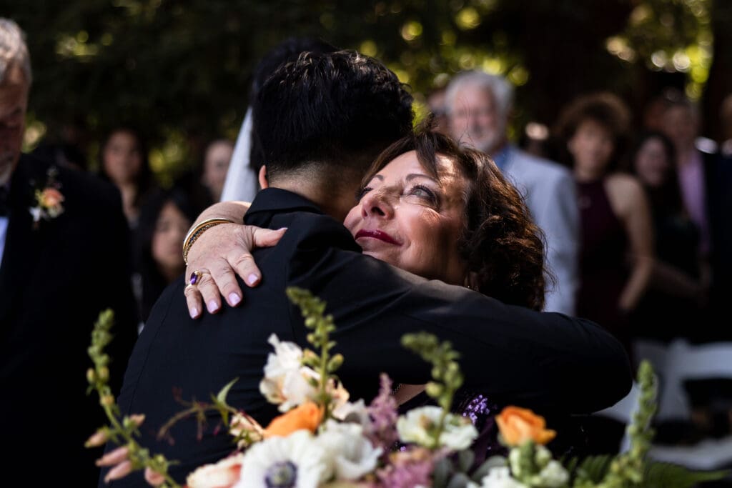 Mother of the bride tearing up and hugging the groom before the Vine Hill House wedding ceremony