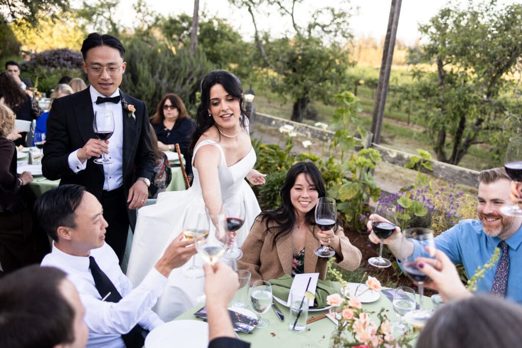 Bride and groom giving cheers with their wedding guests at Vine Hill House wedding