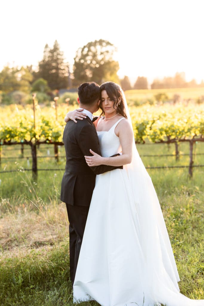 Bride and groom hugging at sunset photos at winery wedding at Vine Hill House