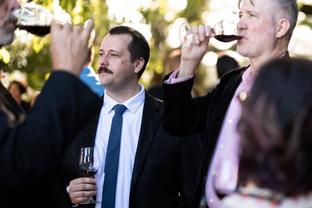 Wedding guests drinking wine and having conversation at Sonoma County wine country wedding