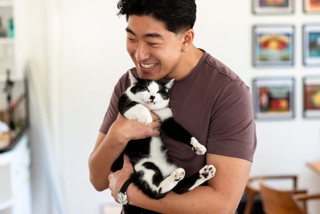Groom, Steven, if hugging his cat before his wedding at Vine Hill House in Sonoma CA