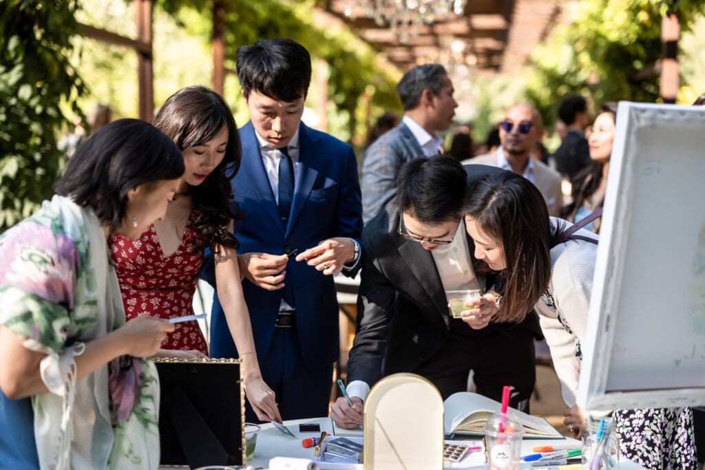Wedding guests writing in guest book at Nestldown wedding reception
