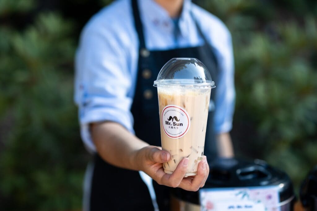 Caterer holding a boba drink at wedding reception