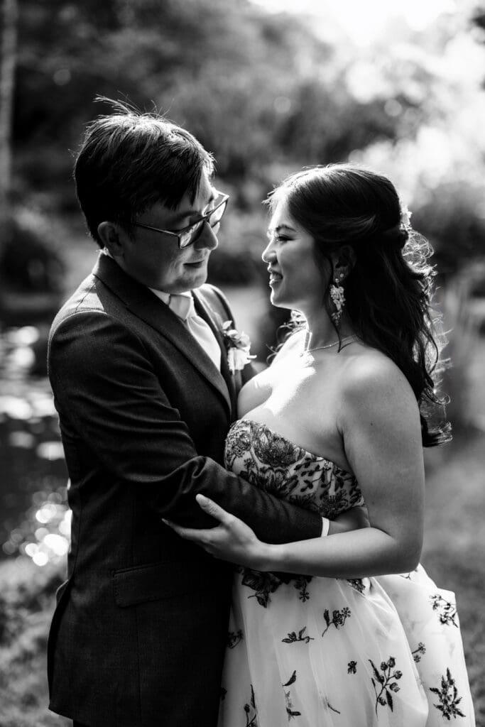 Black and white photo of bride and groom holding each other at wedding reception