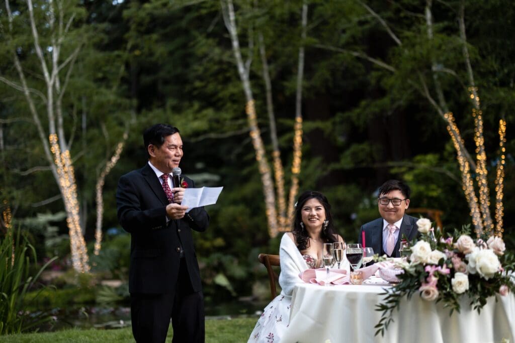 Wedding speech at Nestldown wedding reception with bride and groom smiling