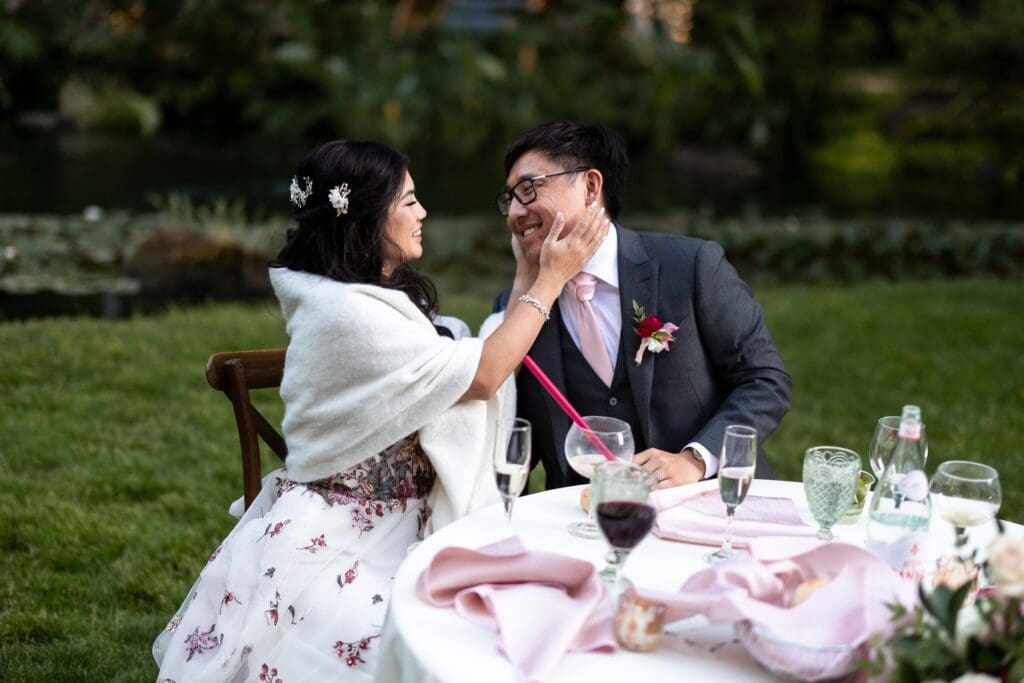 Bride holding grooms face at outdoor wedding reception at Nestldown