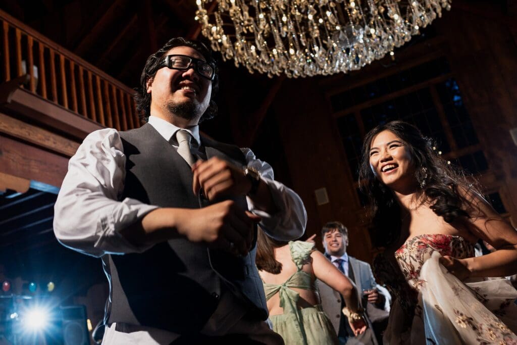 Bride laughing with groom and dancing at wedding reception