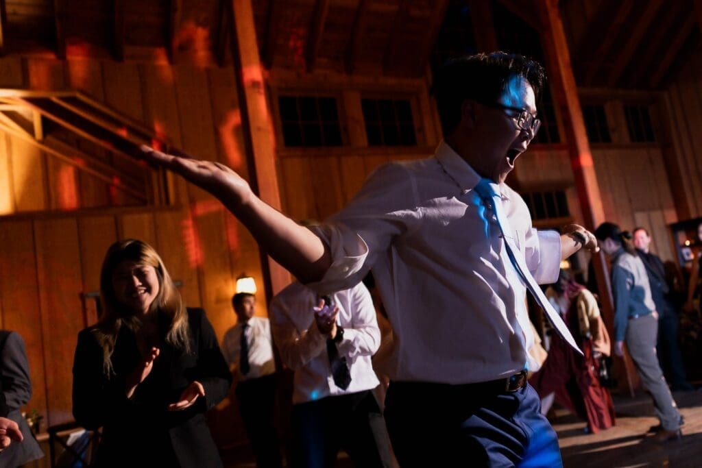 Wedding guest dancing with guests laughing in the background