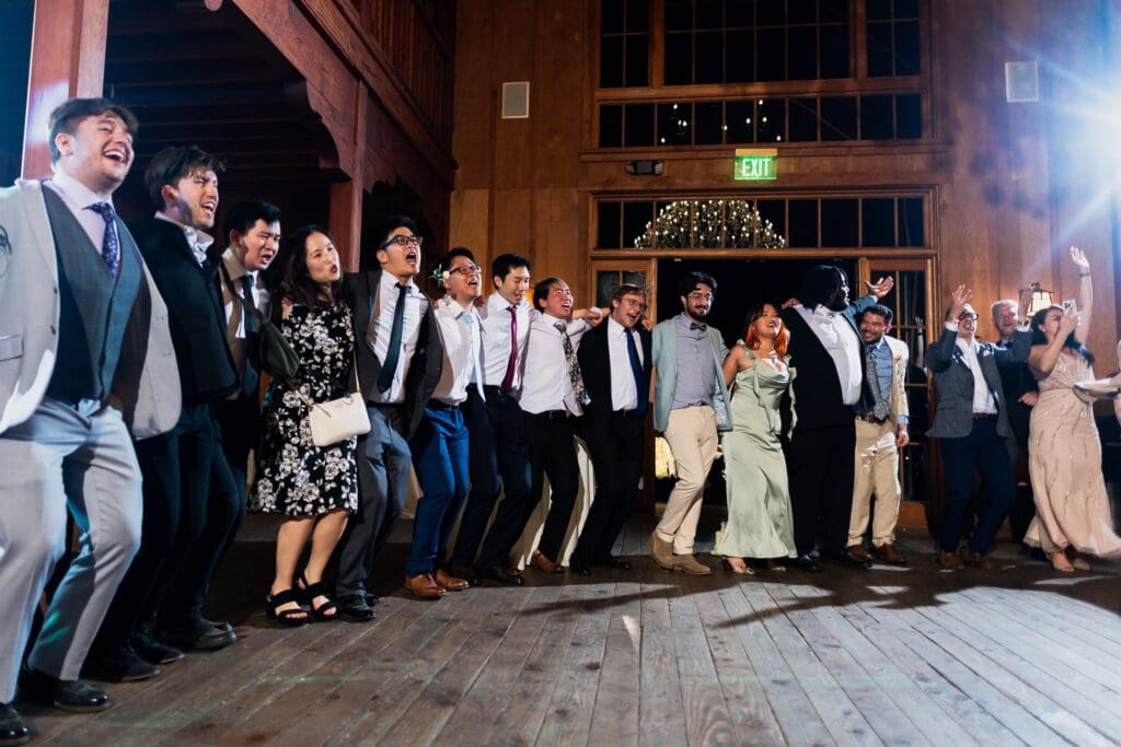 Wedding guests holding hands and arms dancing at the end of a Nestldown wedding