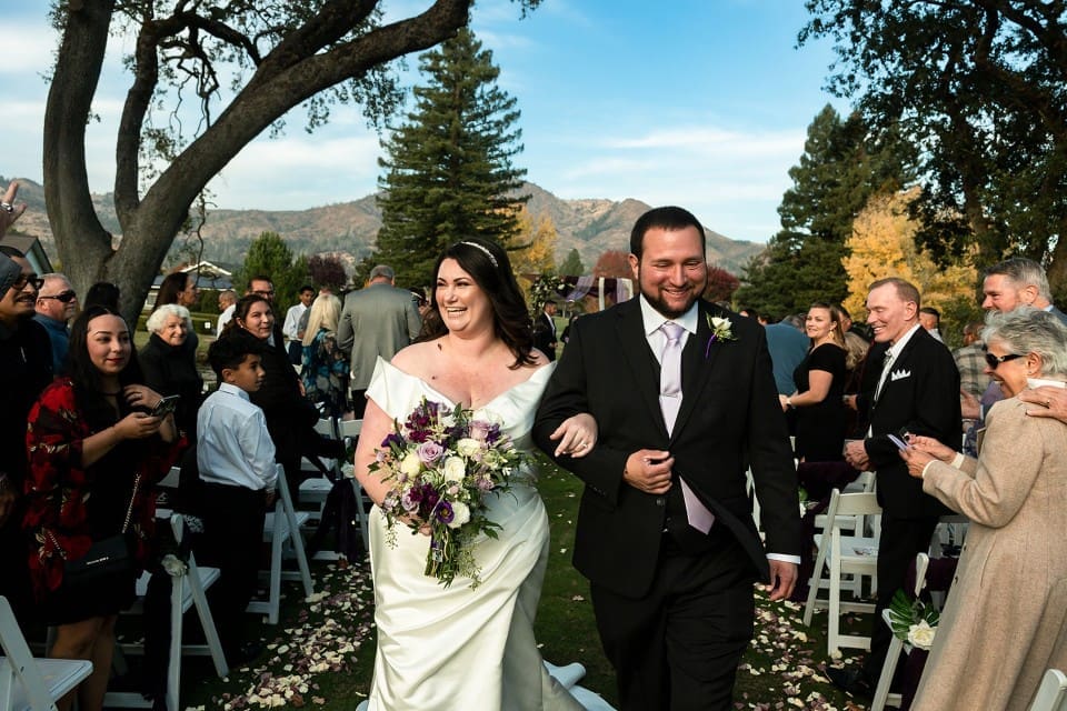 Bride and groom arm-in-arm walking down the aisle