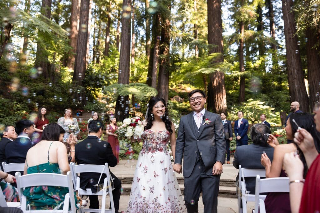 Bride and groom walking down the aisle of their wedding ceremony smiling at Nestldown wedding