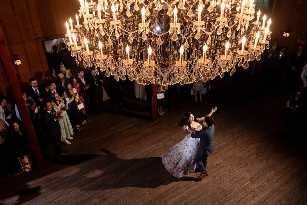 Bride and groom dancing below chandelier at Nestldown wedding in Northern California