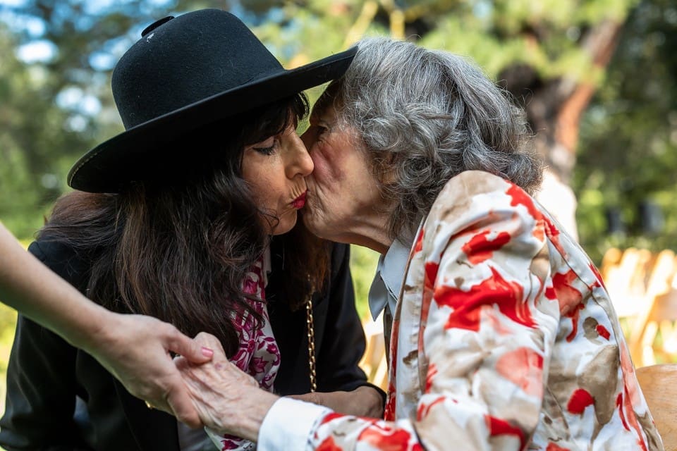 Grandmother and granddaughter kissing during wedding ceremony