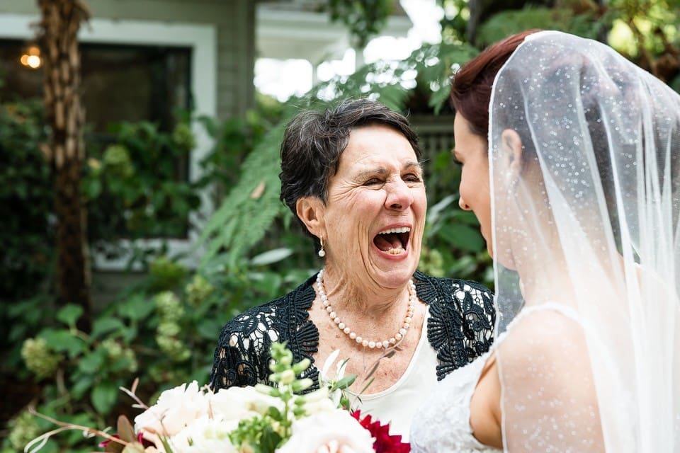 Grandmother happily smiling at bride reveal on wedding day