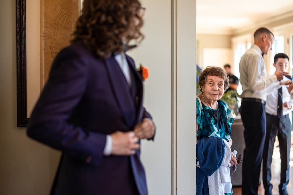 Groom looking at smiling grandmother before wedding ceremony