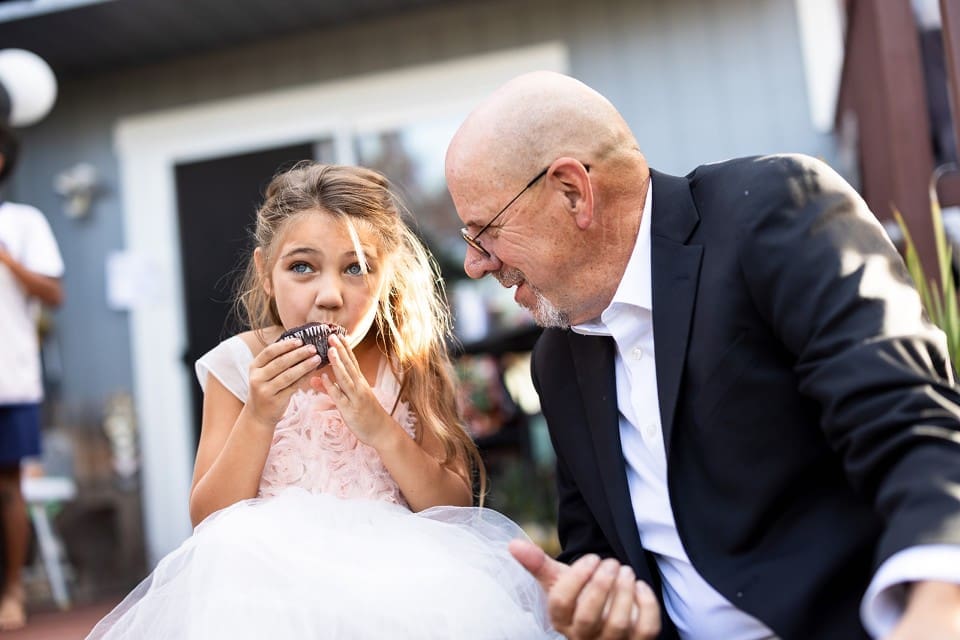 Grandfather watching flower girl and smiling at wedding ceremony