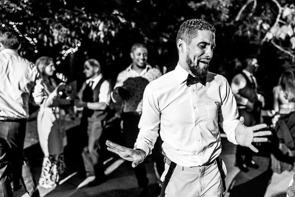 Black and white photo of wedding guests dancing at wedding reception