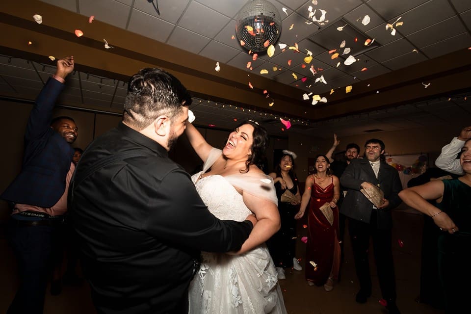 Bride and groom dancing on the dance floor and laughing at reception
