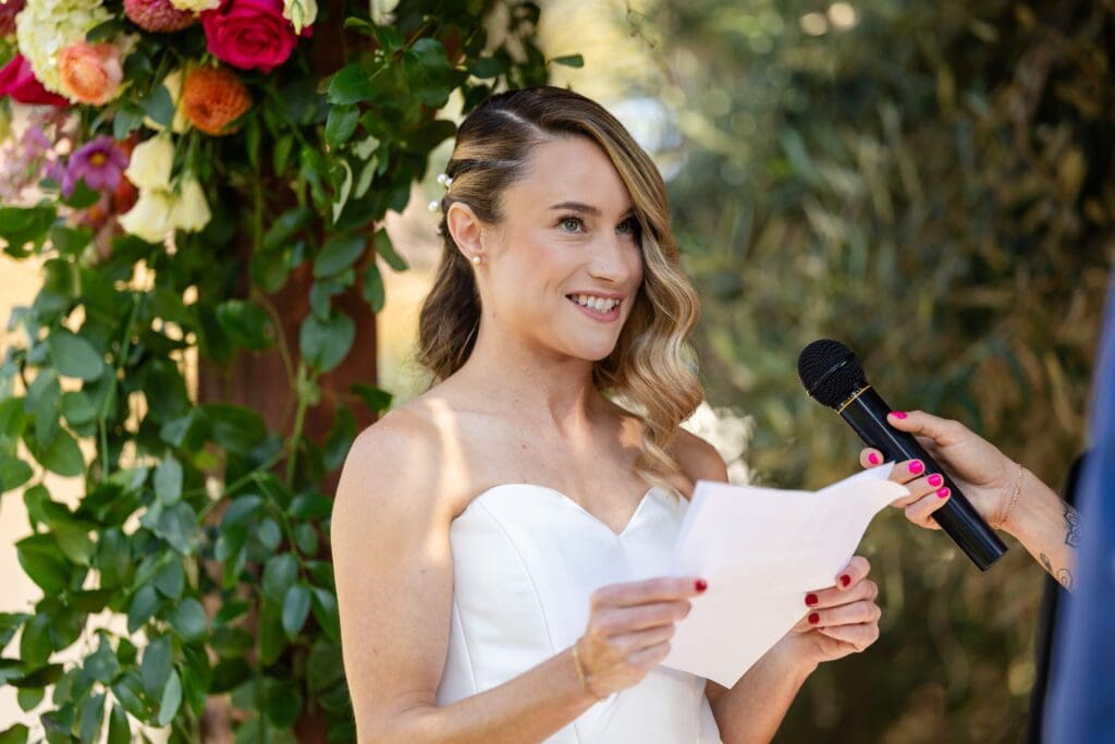 Bride in Flying Cloud Farm holding her vows and smiling