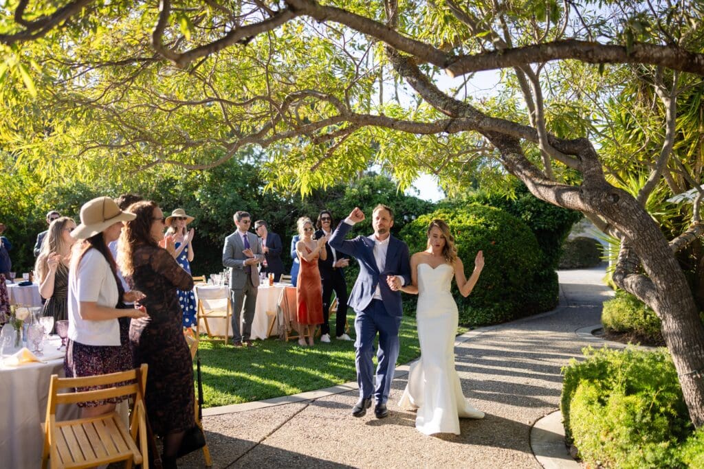Bride and groom walking down the aisle and waving to guests at Northern California wedding