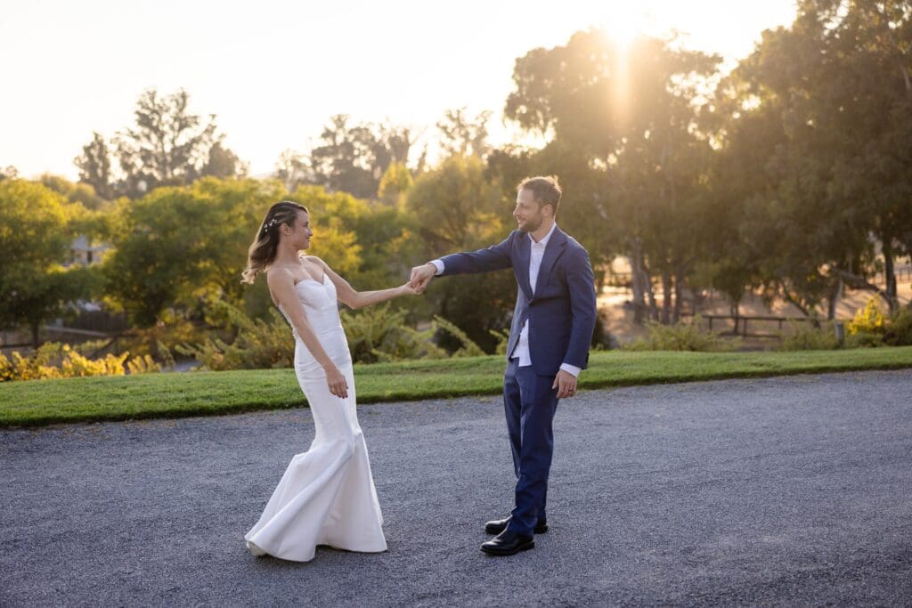 Bride and groom holding hands at Flying Cloud Farm sunset