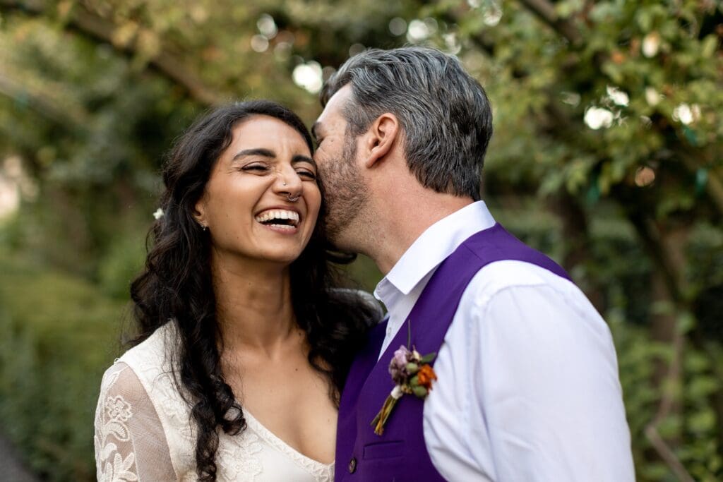 Groom kissing bride's cheek at Garden Valley Ranch wedding