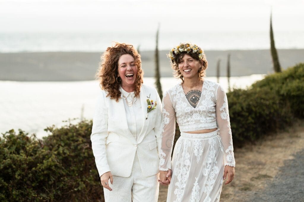 Brides holding hands and walking at Gualala Arts Center