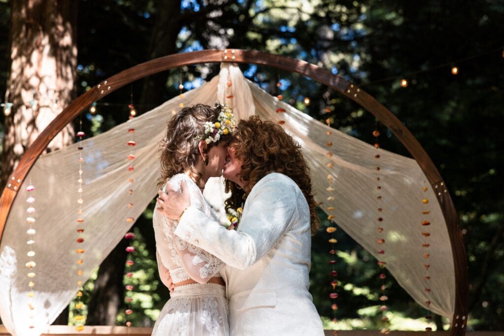 Brides kissing at Gualala wedding ceremony