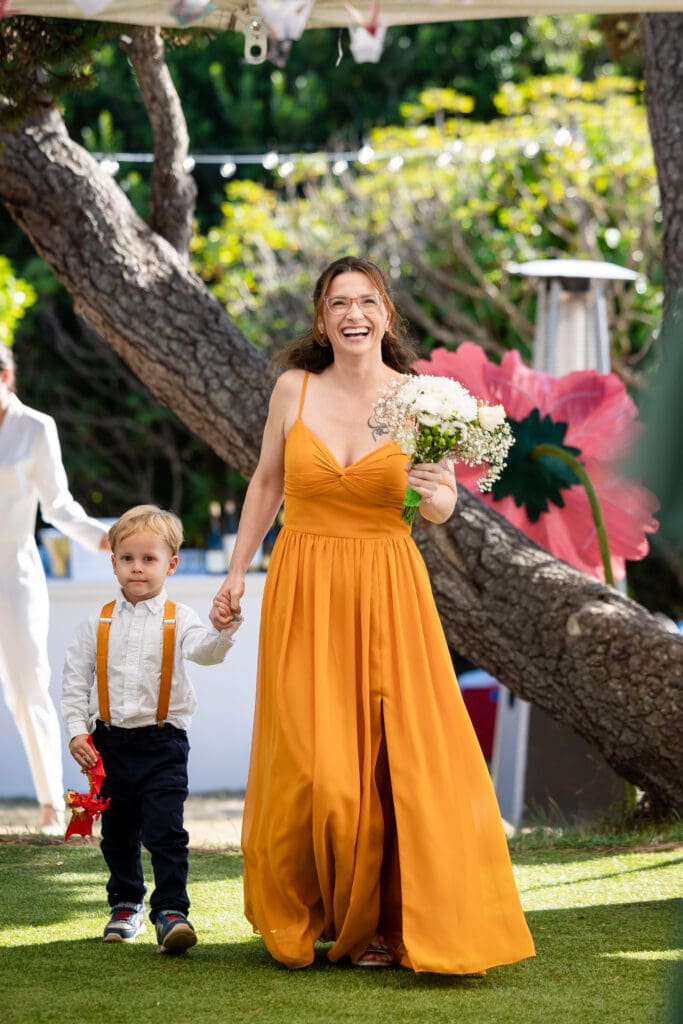 Bridal party member with yellow dress holding hands with boy before walking down the aisle at Fort Bragg wedding