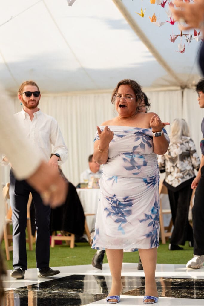Wedding guest dancing in floral dress at at Holly’s Ocean Meadow in Fort Bragg, CA