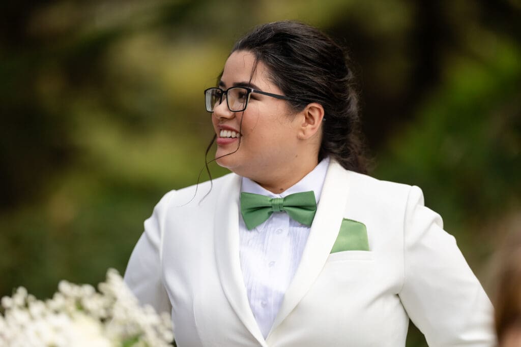 Bride smiling with bouquet and green accents at Northern California wedding