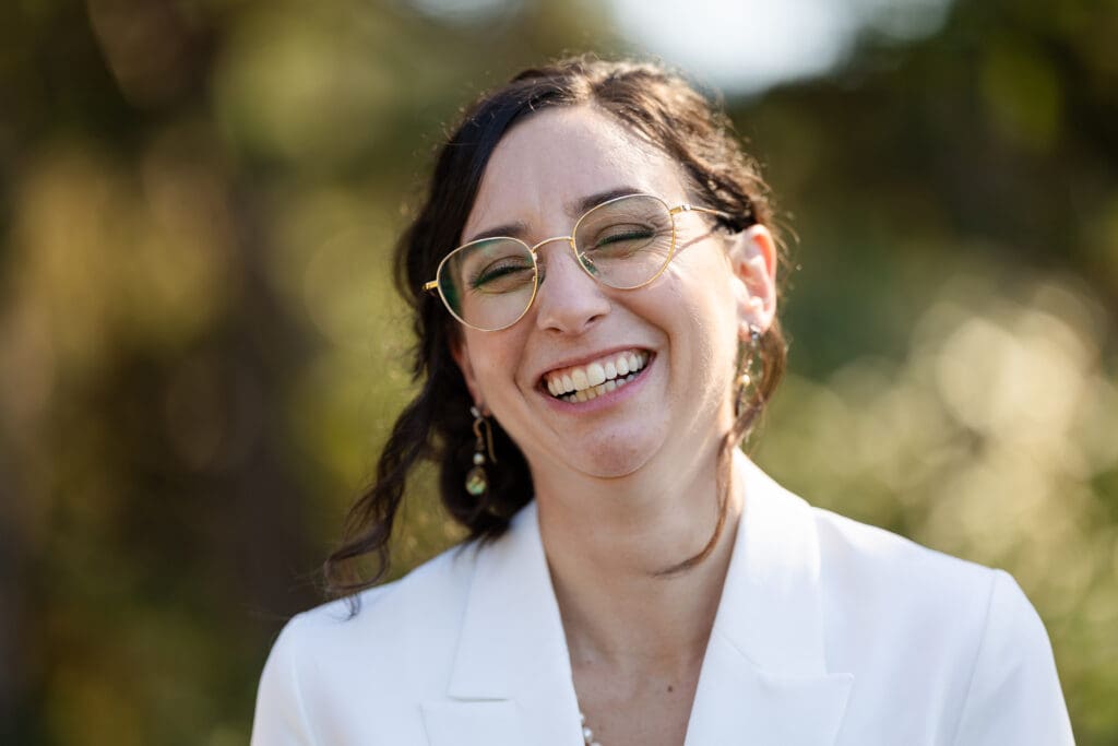 Bride with glasses smiling while walking down the aisle at wedding in California