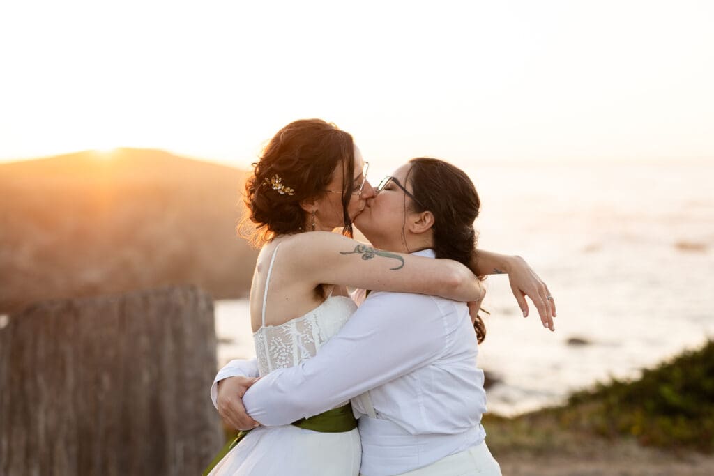 Brides kissing with arms around each other in Fort Bragg CA wedding