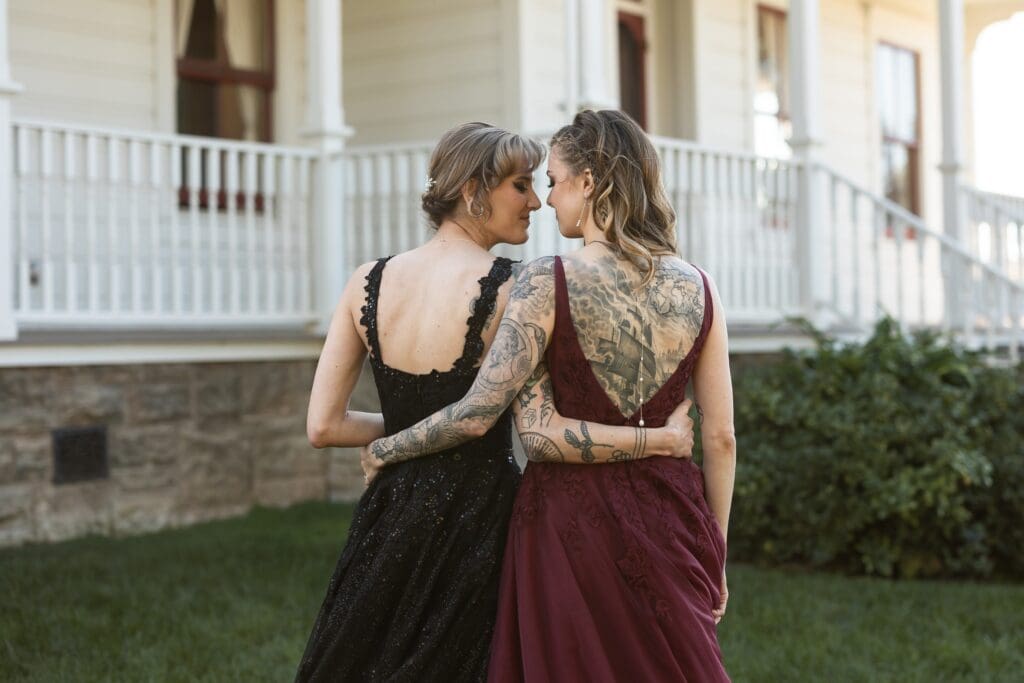 Brides holding each other's waist in a side hug at Olympia's Valley Estate