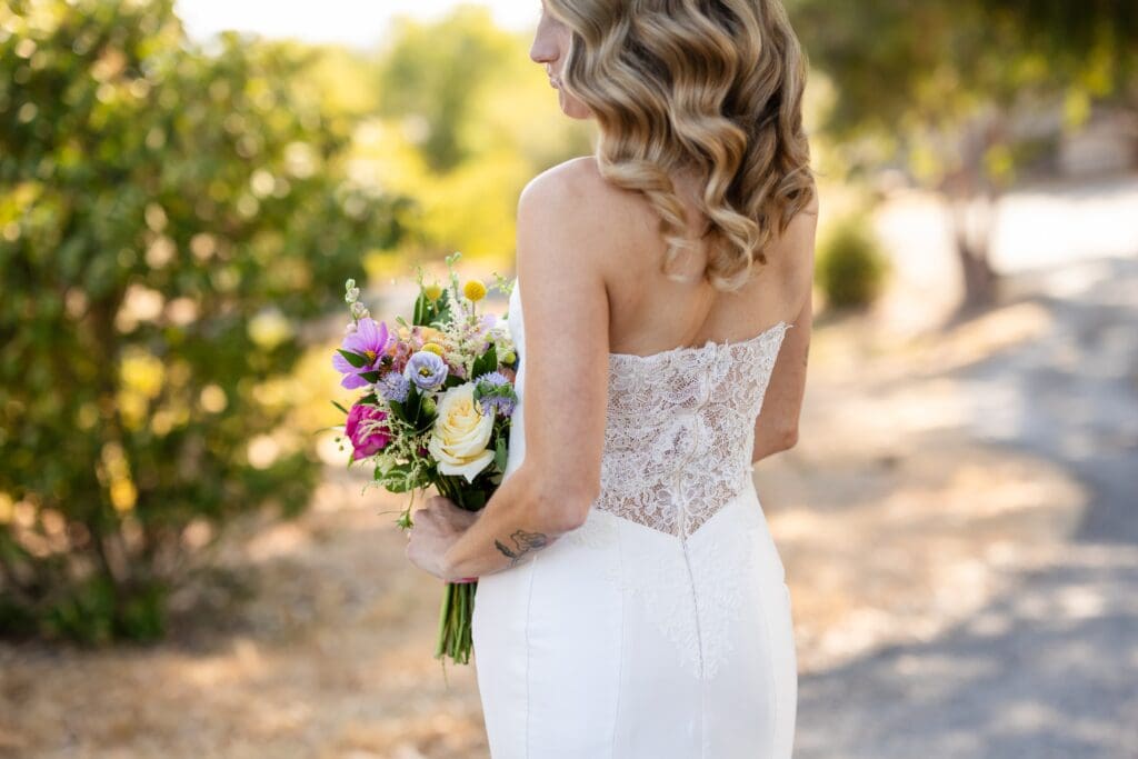 Bride standing with bouquet of flowers at Petaluma wedding ceremony