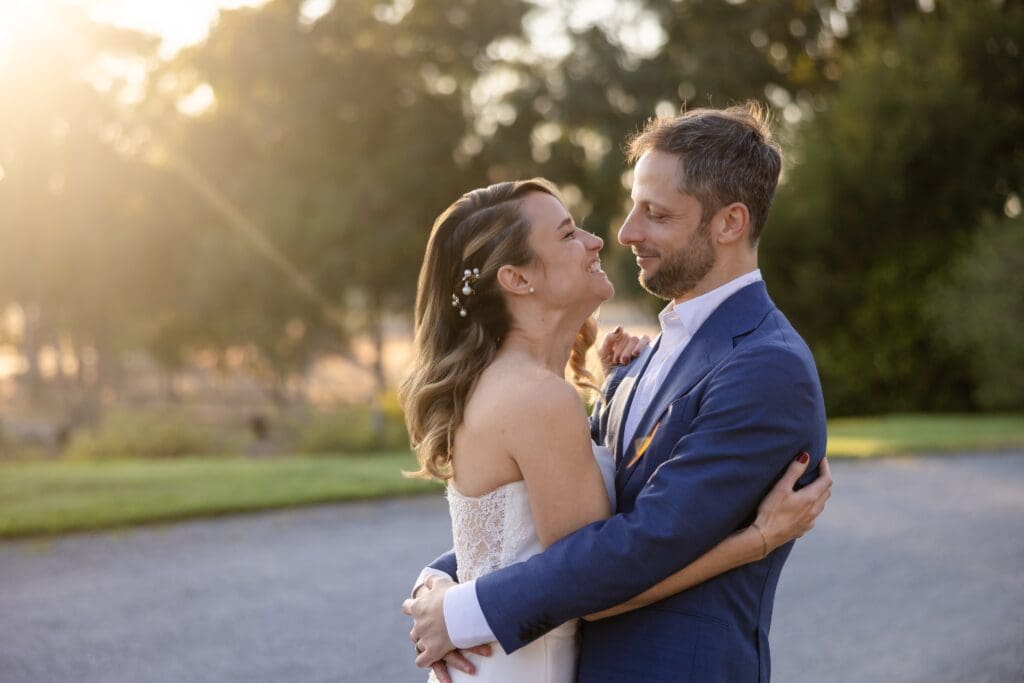 Bride and groom hugging in the sunset glow at Flying Cloud Farm