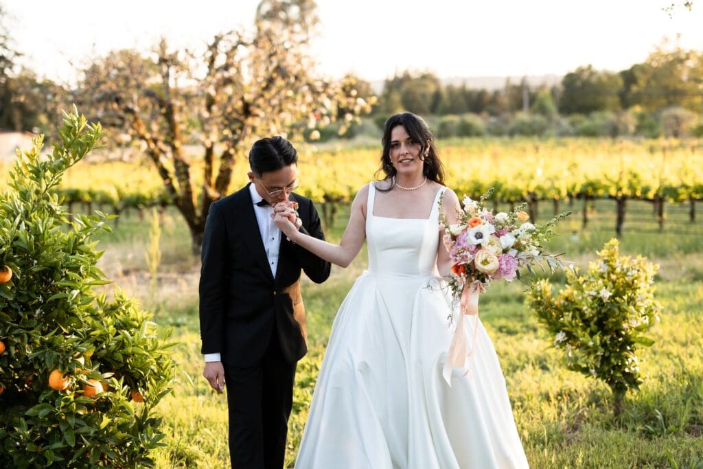 Groom kissing bride's hand at Vine Hill House in Sonoma County