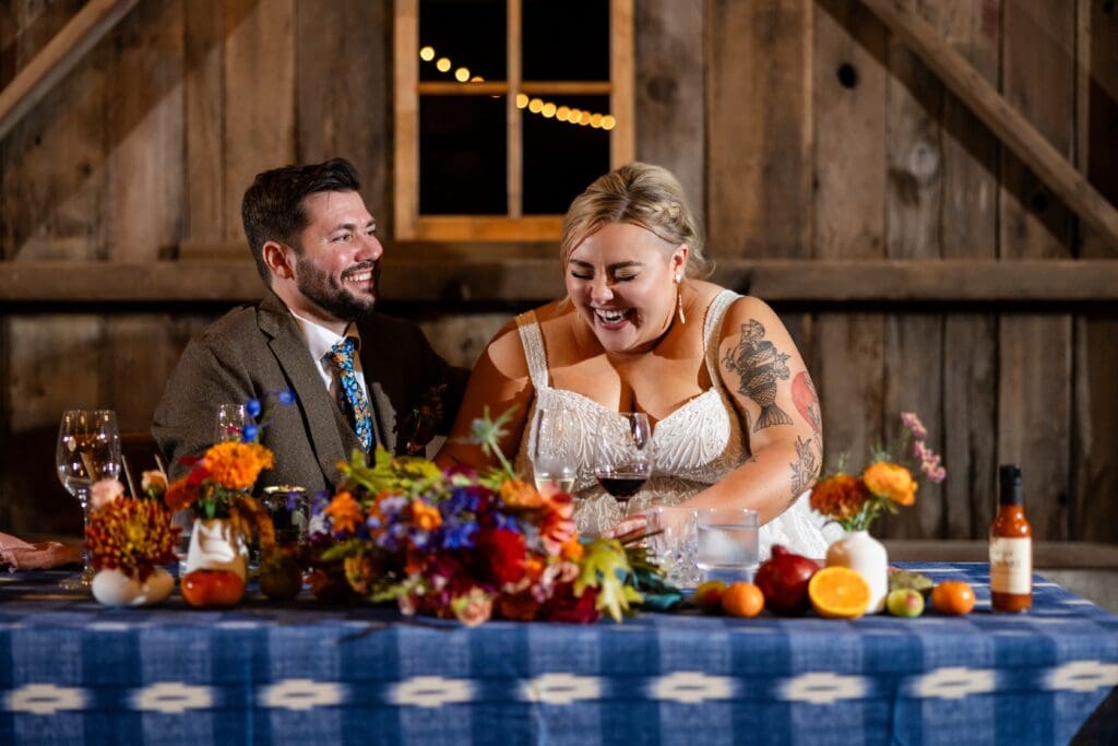 Bride and groom laughing at head table at Tomales wedding reception