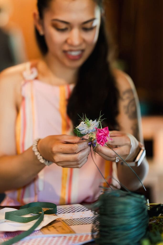 Guests making their own boutonnieres at a Mendocino Woodlands wedding retreat