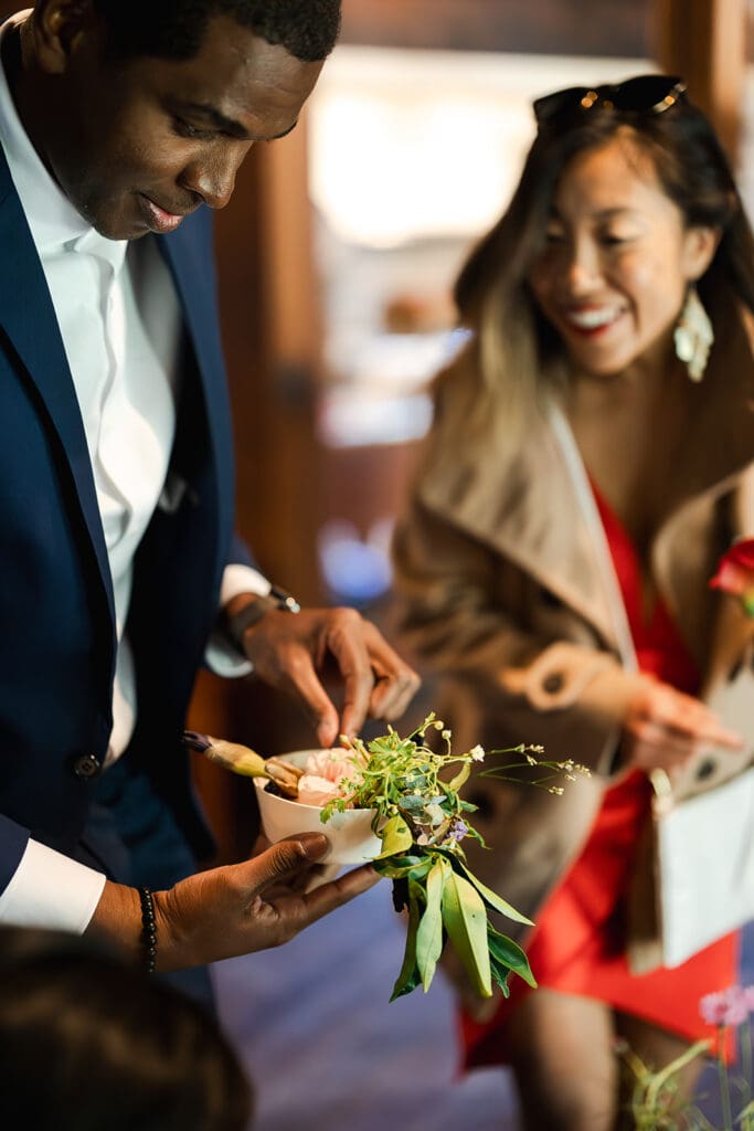 Guests making their own boutonnieres at a Mendocino Woodlands wedding retreat