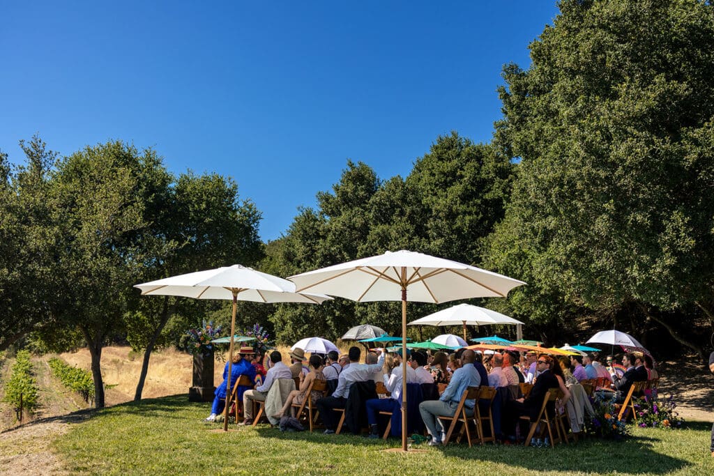 Guests holding colorful parasols during a summer wedding ceremony in Sonoma County