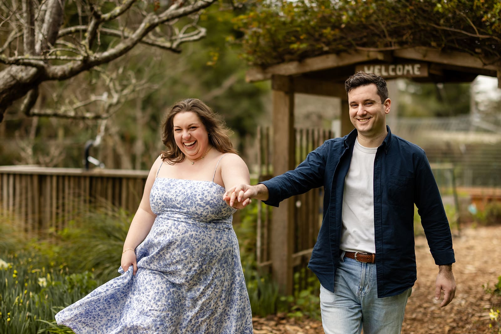 Couple walking through Mendocino Coast Botanical Gardens during engagement session