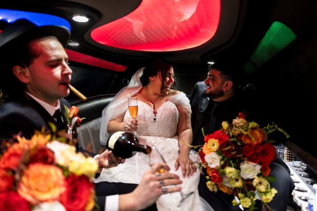 Bride and groom share a champagne toast in a limo on their way to their Petaluma wedding reception.