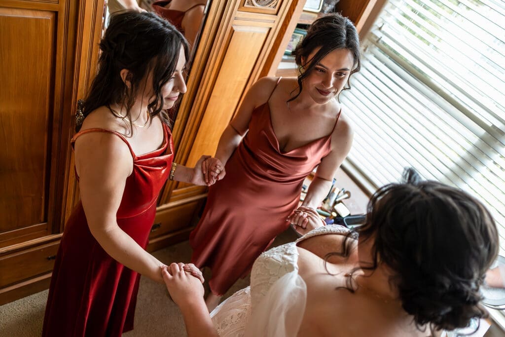 Bride and bridesmaids gather for a pre-ceremony prayer while getting ready for her intimate petaluma wedding.