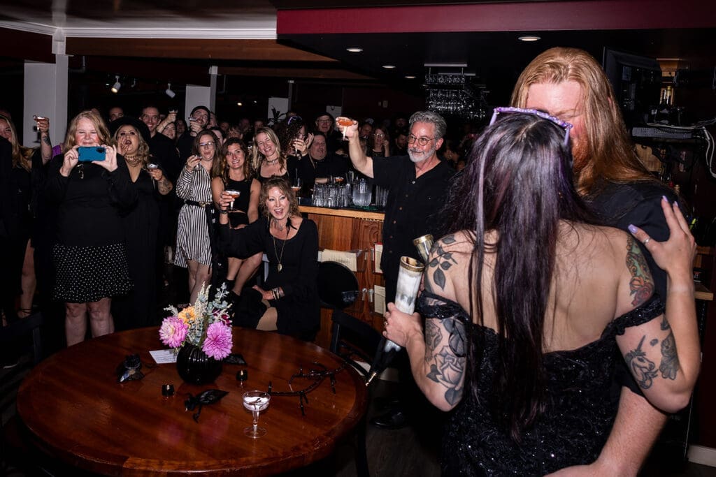 Couple shares kiss while guests watch at Noyo River Grill wedding reception