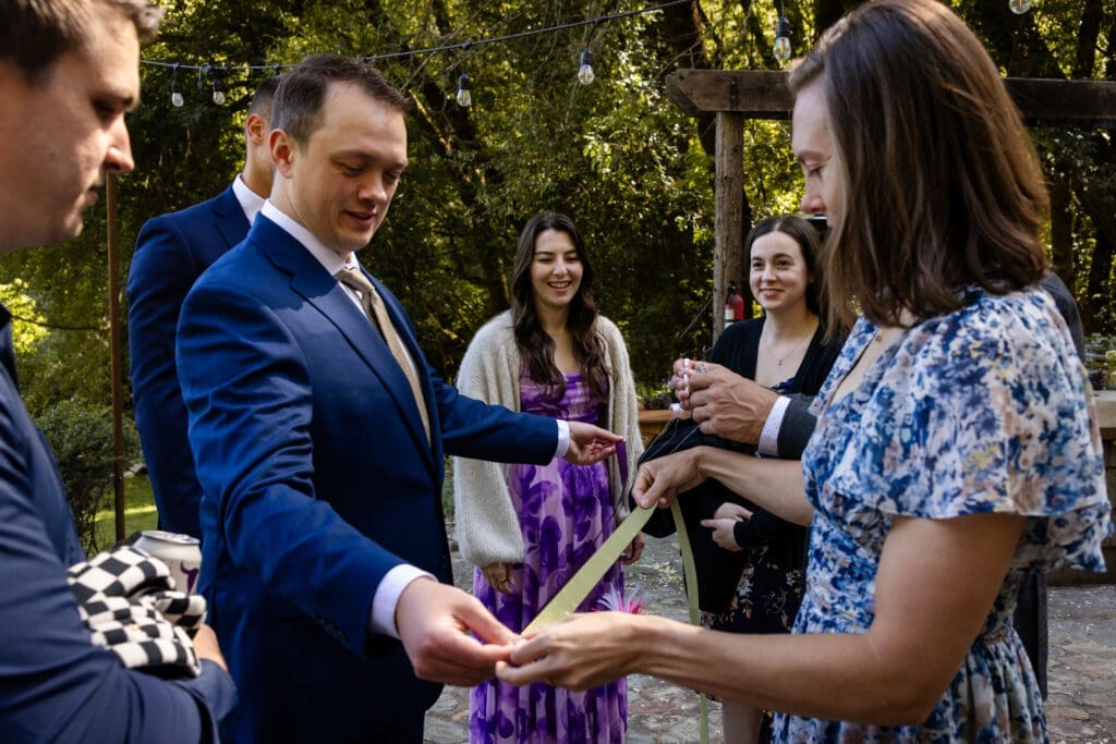 Wedding party holding handfasting ribbons before a ceremony at Leonard Lake Reserve
