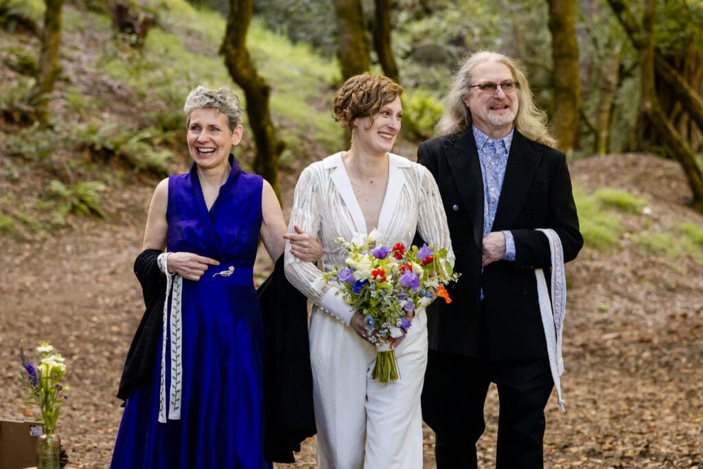 Outdoor wedding ceremony under oak trees with Leonard Lake in the background