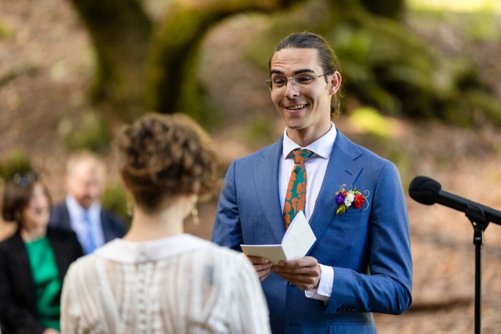 Outdoor wedding ceremony under oak trees with Leonard Lake in the background