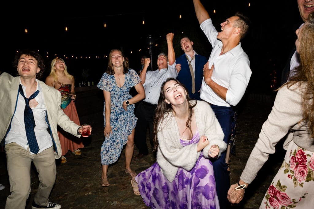 Wedding guests dancing under string lights at a Leonard Lake Reserve summer camp wedding